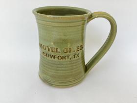 Hotel Giles green ceramic mug, logo to front when held in left hand