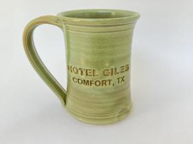 Hotel Giles green ceramic mug, logo to front when held in right hand