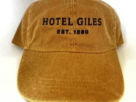 Tan fabric adjustable cap with cream embroidered Hotel Giles logo