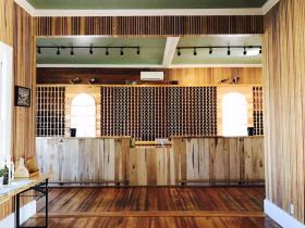 open room with wood floor, wood bar, and wine rack on wall