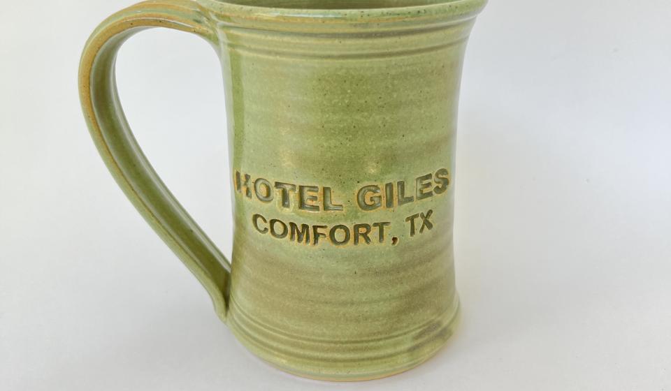 Hotel Giles green ceramic mug, logo to front when held in right hand
