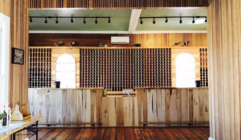 open room with wood floor, wood bar, and wine rack on wall