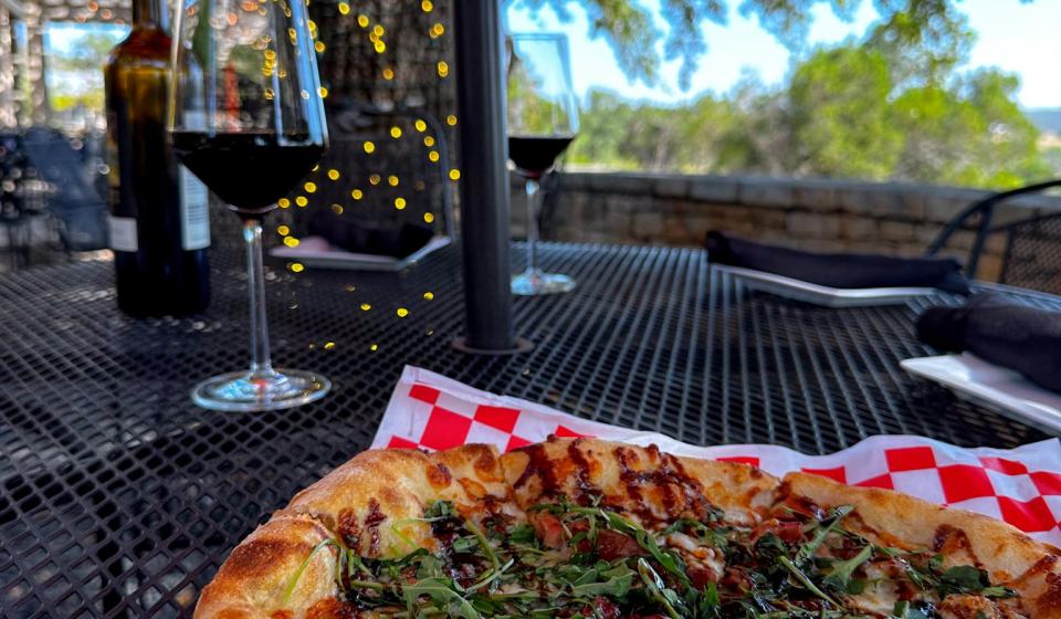 Pizza with wine and scenery in background