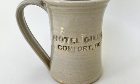 Hotel Giles white ceramic mug logo to front when held in right hand