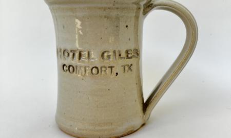 Hotel Giles white ceramic mug logo to front when held in left hand