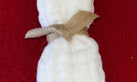 White exfoliating cloth wrapped with ribbon